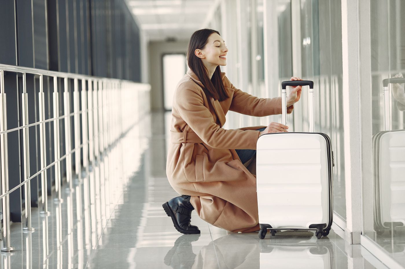 Traveler with her suitcase enjoying a quiet moment at the airport